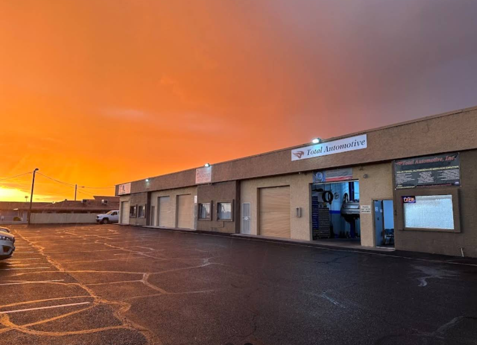 The Total Automotive & Performance shop in Apache Junction under an Arizona sunset